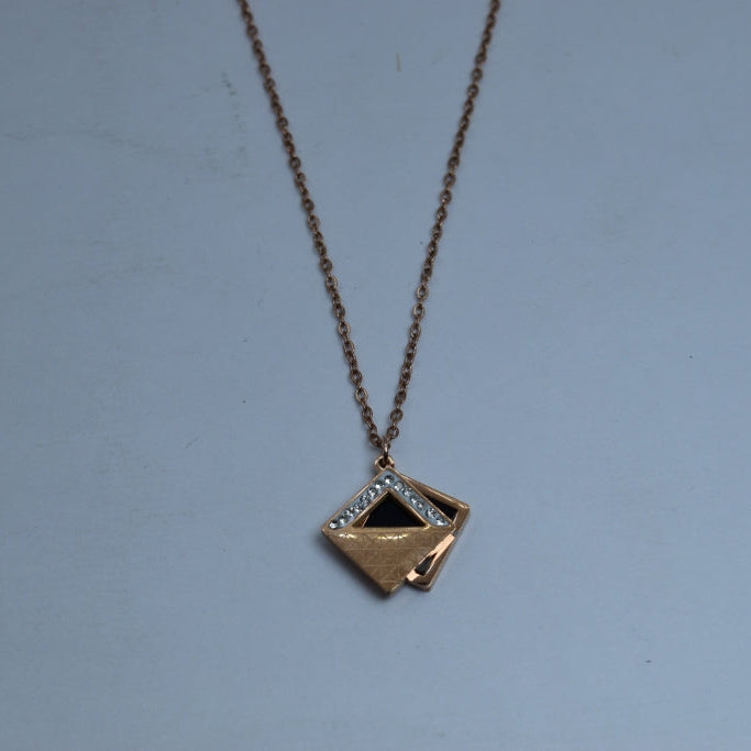 Gold necklace with a diamond pendant on a light blue background