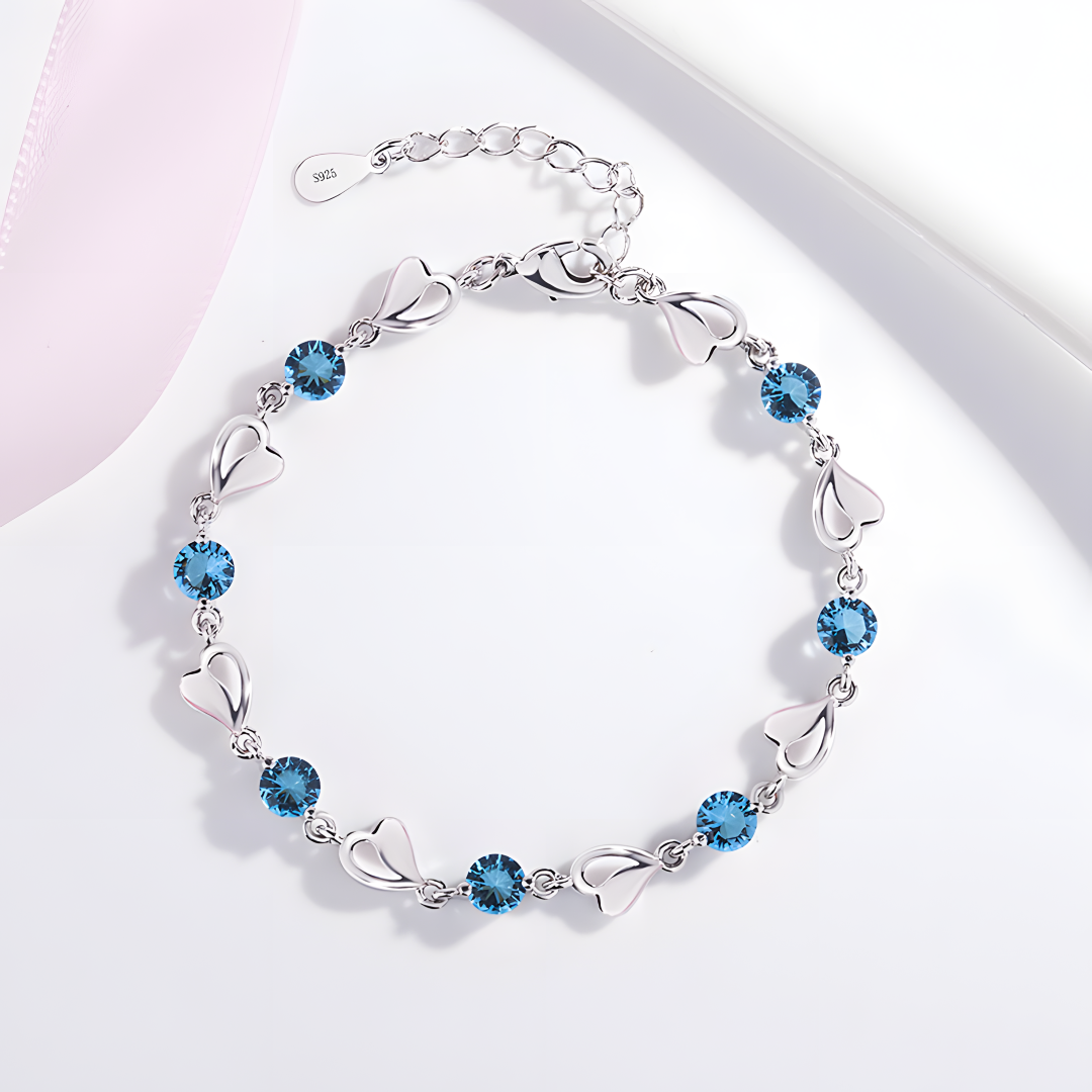 Silver bracelet with blue heart-shaped stones on a white background