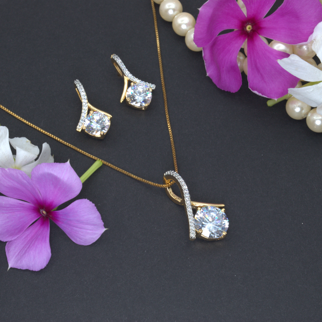 Jewelry set with necklace and earrings on a dark surface with flowers.