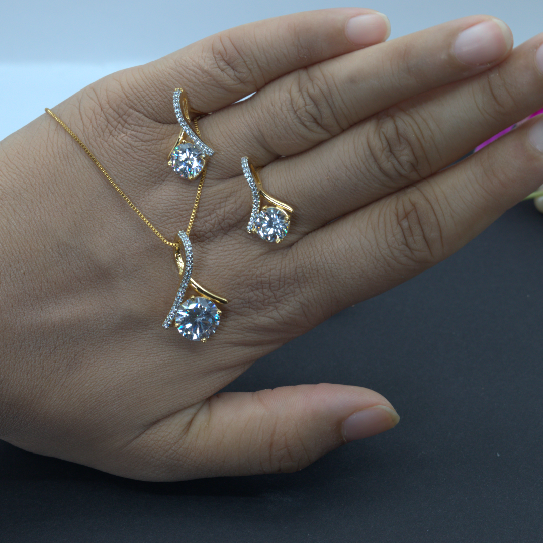 Hand wearing gold diamond studded jewelry with a pearl necklace on a dark surface.